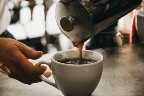 pouring coffee into a cup from a French press